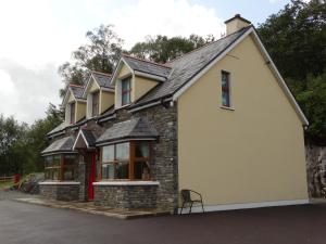a house with a stone and black roof at The River House in Releagh