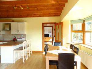a kitchen and dining room with a table and a table and chairs at The River House in Releagh