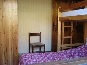 ein Schlafzimmer mit einem Stuhl und einem Etagenbett in der Unterkunft Chalet de Basseville in Combloux