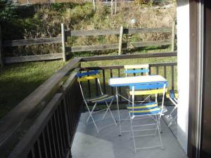 una mesa y sillas en un porche con una valla en Chalet de Basseville, en Combloux
