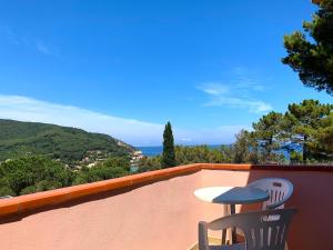 a patio with a table and chairs on a balcony at Le 3 case di Mia in Marciana Marina