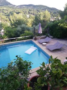 einen Pool mit 2 Liegestühlen und einem Sonnenschirm in der Unterkunft Chambre lumineuse, calme absolu in Allauch