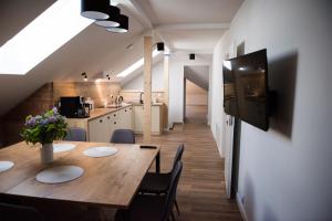 a kitchen and dining room with a wooden table and chairs at Apartament, pokoje ,domek Ach To Tu in Mikołajki