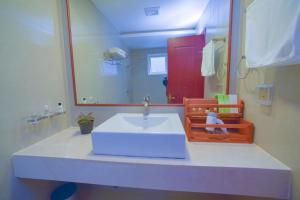 een badkamer met een witte wastafel en een spiegel bij Turquoise Residence by UI in Hulhumale