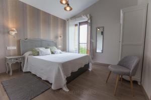 a bedroom with a bed and a chair and a window at Endaneta Berri in Zumaia