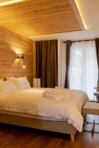 a bedroom with a large white bed with a window at Hotel SNOW CHILL in Risoul