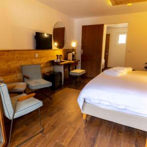 Schlafzimmer mit einem Bett, einem Schreibtisch und einem TV in der Unterkunft Hotel SNOW CHILL in Risoul
