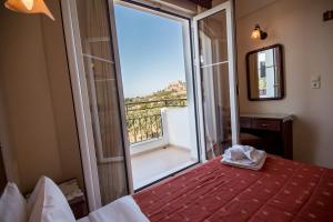 a room with a bed and a large glass door with a balcony at Eriphilly Studios & Apartments in Mythimna +16 photos