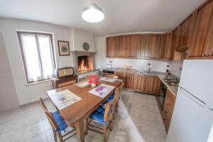 a kitchen with a wooden table and a fireplace at Rustico alla Quercetta in Verona