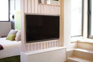 a large flat screen tv in a room with a bed at Exclusivo ático en el centro de Castro Urdiales in Castro-Urdiales