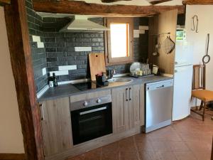 a kitchen with a stove and a sink and a refrigerator at Casa Marqueso in Figuerola de Orcau