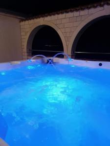 uma grande piscina com água azul em frente a um edifício em Apartments Villa Anna em Podstrana
