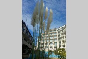 un grand bâtiment blanc avec de l'herbe haute devant lui dans l'établissement Studio at "The Cliff" complex South Beach Obzor, private appartment A2A5, à Obzor