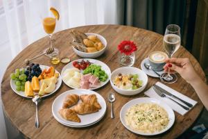 a wooden table with plates of food and glasses of wine at Boutique hotel Corso in Řevnice