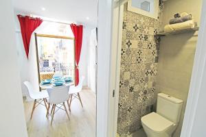 a bathroom with a table and a toilet and a room with a window at Apartamento muy céntrico 5 minutos playa (2º) in Alicante