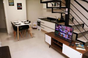 een woonkamer met een tv en een keuken met een tafel bij POUSADA GERMÂNICA in Marcelino Ramos