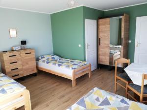 a bedroom with two beds and a dresser and a mirror at Pokoje Jadwiga Konkel in Jastarnia