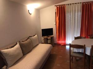un soggiorno con divano e tavolo con TV di Guesthouse MB Knezevic a Budua