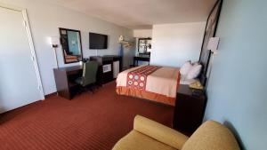 ein Hotelzimmer mit einem Bett, einem Schreibtisch und einem Stuhl in der Unterkunft Super 8 by Wyndham Van Horn in Van Horn