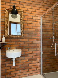 a bathroom with a brick wall with a sink and a mirror at Pensjonat Kupperówka- Stadnina Koni Kolano in Szymbark +23 photos