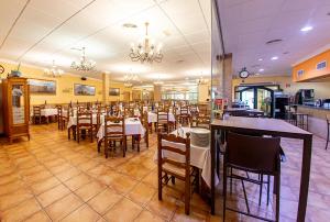 un comedor con mesas y sillas en un restaurante en Hospedium Hotel Don Jose, en Castalla