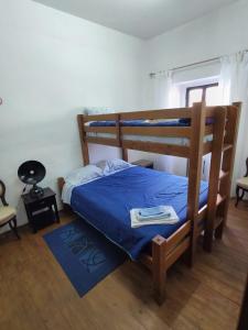 a bedroom with a bunk bed with a blue bedspread at Casa do Povo in Gomes Aires