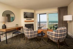 a living room with a desk and chairs with a view at Shearwater Inn in Lincoln City