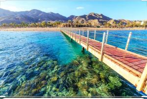 een dok in het water naast een strand bij Eleni apartment Eilat in Eilat