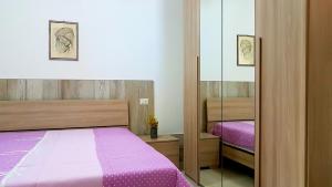 een slaapkamer met een bed en een spiegel bij Appartamenti Enza&Giuseppe in Peschici