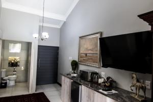 a living room with a large flat screen tv on the wall at 64 on Malabor in Pretoria