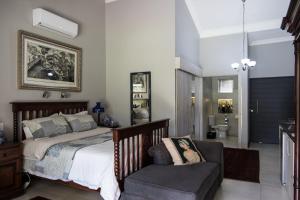 a bedroom with a bed and a chair at 64 on Malabor in Pretoria