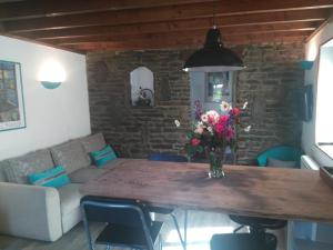 ein Wohnzimmer mit einem Tisch und einer Blumenvase in der Unterkunft Le Pti' chez vous in Saint-Omer