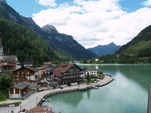 a town next to a body of water with mountains at Appartamenti Katinanna in Alleghe