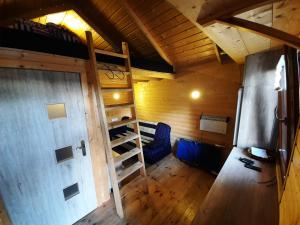 an attic room with a bunk bed and a door at Niewygodny Domek z własnym podwórkiem in Wisełka