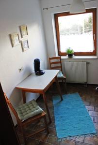 ヴァンゲン・イム・アルゴイにあるFerienwohnung Alpsteinwegのテーブルと椅子、窓が備わる客室です。