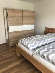 ケルベルクにあるFerienwohnung Göbelのベッドルーム1室(木製ヘッドボード付きのベッド1台付)