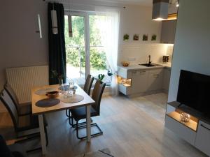a kitchen and dining room with a table and chairs at Apartament Zielone Wzgórze in Jelenia Góra