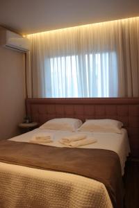 um quarto com uma cama grande com duas toalhas em Alpen Hospedagem em Treze Tílias