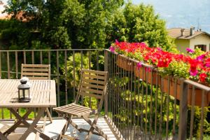 2 Stühle und ein Tisch auf einem Balkon mit Blumen in der Unterkunft Griante suites in Griante Cadenabbia