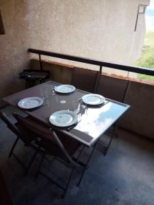 stół z czterema krzesłami i talerzami w obiekcie LE FONTAGNEL N°310 w mieście Molines-en-Queyras