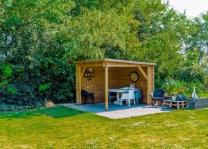 a small shed with a table in a yard at Bed en Bike Texel in Den Burg