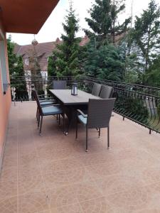 a patio with a table and chairs on a balcony at Willa Aleksandra in Żarnowska