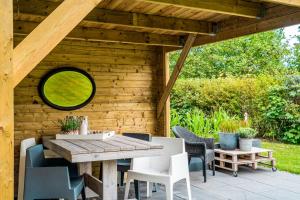 a wooden patio with a table and chairs at Bed en Bike Texel in Den Burg