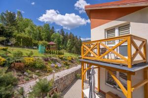 a balcony on the side of a house with a garden at DOMINO - pokoje i apartamenty in Szklarska Poręba