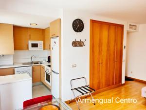 une cuisine avec une porte en bois et une chaise à l'intérieur dans l'établissement Armengual Centro Apartments FREE PARKING By Easytrip, à Malaga 28 autres photos