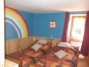 dwa łóżka w pokoju z tęczą na ścianie w obiekcie Mas de La Boheme - L'Hermet w mieście Saint-Léons