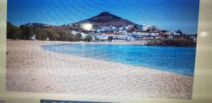 une photo d'une plage avec une ville en arrière-plan dans l'établissement Ragoussis House, à Logaras