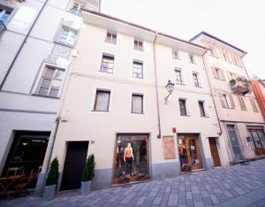 a white building on a street with a store window at Maison Ville d'Aoste in Aosta