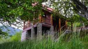 ein Haus mit einem Balkon an der Seite in der Unterkunft FERN FARM ECO RESORT in Mojkovac