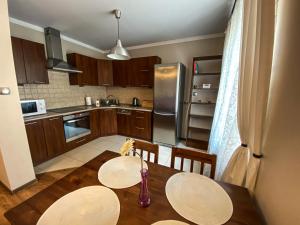 a kitchen with a table with two chairs and a vase at Apartament Przy Długosza in Sandomierz